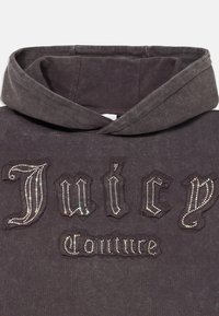 Sivá mikina s kapucňou s veľkým, textúrovaným logom "Juicy Couture" zdobeným lesklými kamienkami. Mäkká látka s uvoľneným dizajnom kapucne.
