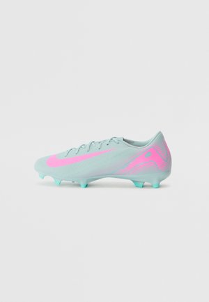 Chaussure de football bleu clair avec un swoosh Nike rose et des détails assortis, crampons moulés sur la semelle, et lacets sur le dessus, vue de profil côté.