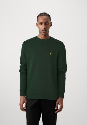 Sweatshirt vert en tissu doux, avec un col rond, des manches longues et un petit logo jaune sur la poitrine gauche.