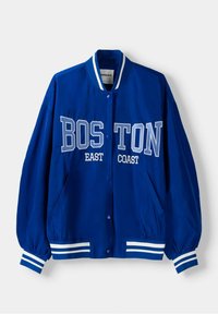 Modrá bomber bunda s bílými nápisy "BOSTON" a "EAST COAST". Má žebrovaný límec, elastické manžety a boční kapsy. Hladká textura.