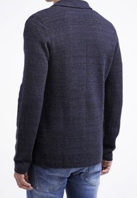 Mörkgrå ull cardigan för män med texturerad stickning, sjalkrage, långa ärmar och en öppen bak sömdesign.