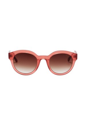 Lunettes de soleil rondes avec montures translucides rose corail et verres dégradés marron sur fond blanc.