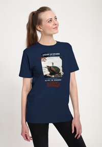 Una camiseta de algodón azul marino con un diseño gráfico de una tortuga en la playa, acompañada de texto en blanco y naranja. Mangas cortas.