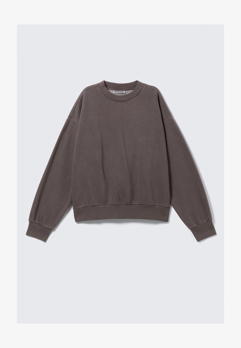 Sweatshirt gris avec un col rond, des épaules tombantes et des poignets côtelés. Fabriqué à partir d'un matériau doux, il présente une coupe décontractée et des coutures subtiles.