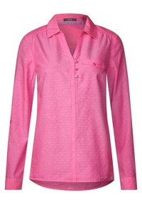 Blusa rosa a maniche lunghe in un tessuto leggero con un sottile motivo a punti, bottoni frontali, colletto e una tasca sul petto.