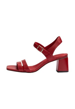 Sandale pour femme en cuir rouge avec talon bloc, deux brides avant et bride de cheville avec boucle dorée, vue de côté sur fond blanc.