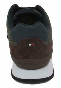 Sneaker da uomo con tomaia in suede marrone, dettagli grigi e una suola intermedia bianca. Presenta un piccolo logo sul tallone e un colletto imbottito.