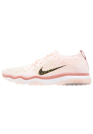 Jasnoróżowy dziany but do biegania Nike z czarnym logo swoosh, falującą podeszwą środkową i przezroczystą podeszwą z amortyzacją Nike Zoom.