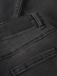 Schwarze Jeans aus Denim mit glatter Textur, sichtbaren Nähten, einem rechteckigen Etikett am Bund und einem Standardtaschendesign.