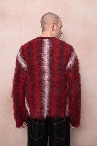 Κόκκινο και άσπρο φουντωτό πλεκτό πουλόβερ με χαλαρή εφαρμογή, με ριγέ σχέδιο και μακρυά μανίκια, σε συνδυασμό με σκούρες τζιν παντελόνες.