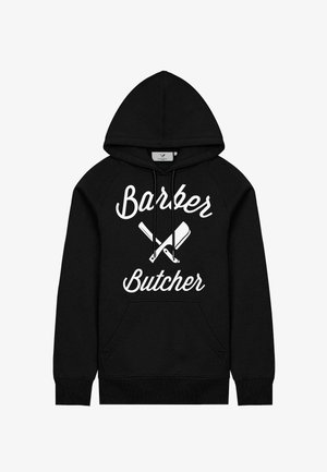 Must jakk, mis on valmistatud pehmest materjalist, esiosa taskuga, suure valge tekstiga "Barber Butcher" ning üksteisega ristuvad nuga kujundused.