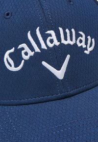 Navy baseball cap with textured fabric, featuring white embroidered "Callaway" logo and a white accent logo on the front.