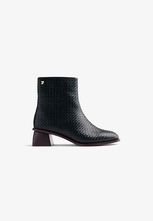 Bottine en cuir tressé noir avec un embout carré et un talon bloc bordeaux contrastant. Fait ressortir un petit accent logo doré.