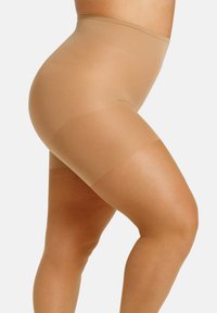 Shorts modellanti beige con vita alta, texture liscia e design senza cuciture, che terminano appena sopra la coscia con una leggera lucentezza.