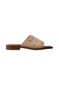 Sandale beige à talon bas en bois avec ornements à œillets dorés sur la large bride supérieure.