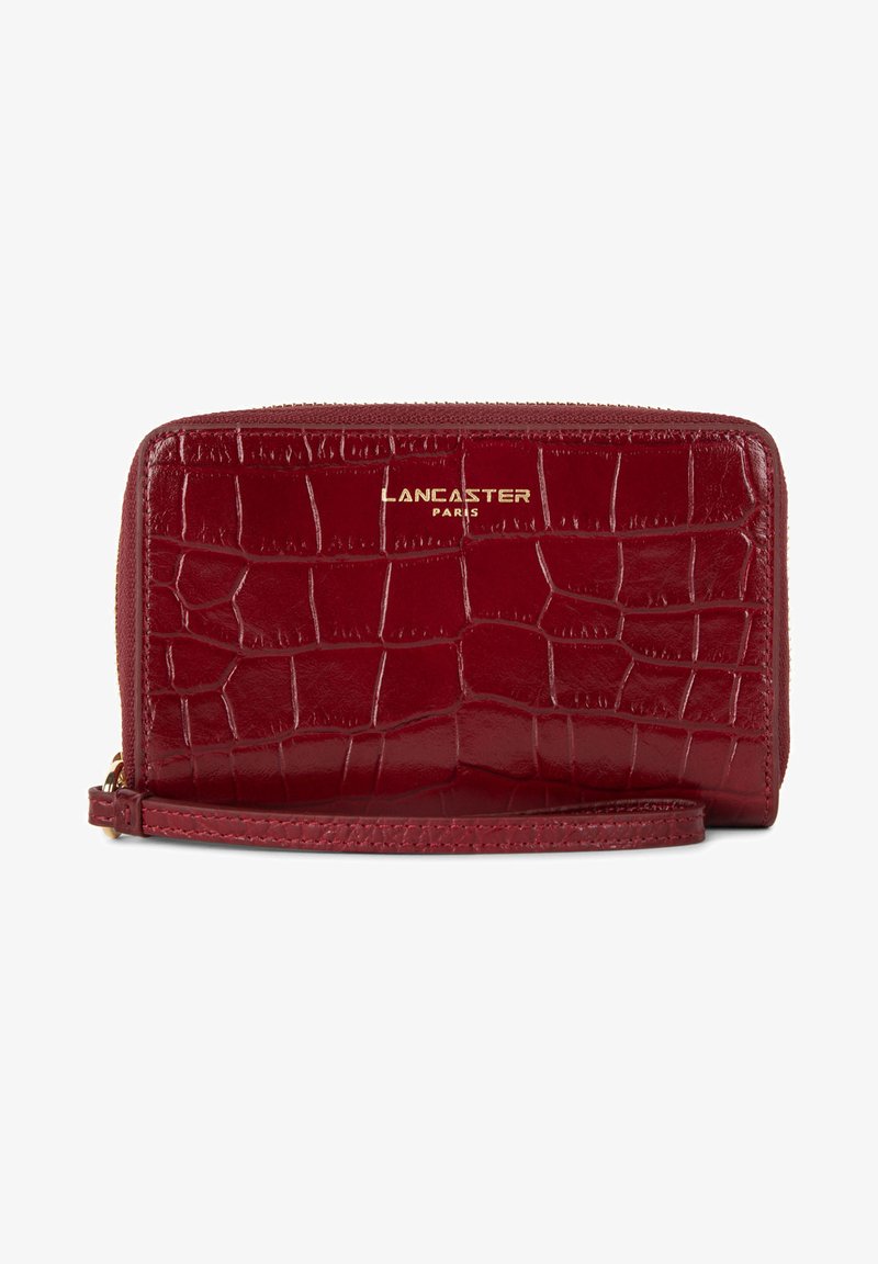 Portafoglio in pelle rossa con stampa a coccodrillo, logo dorato, chiusura a zip e tracolla rimovibile. Finitura liscia e motivo testurizzato.