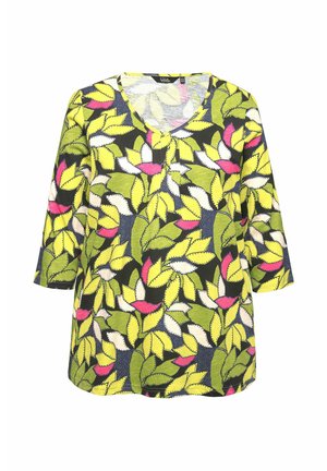 Vzoru s tunikou je V-výstřih, 3/4 rukávy a živý design zelených, žlutých, růžových a bílých listů na tmavém pozadí.