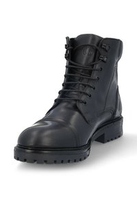 Botín negro de cuero con cordones, con una textura suave, puntera redonda, suela de goma resistente y ocho ojales para los cordones.