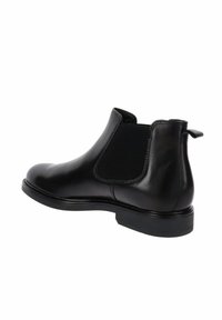 Stivaletto in pelle nera con pannelli elastici ai lati, punta rotonda e linguetta per il tiro. Texture liscia e suola in gomma piatta.