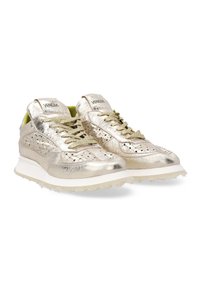 Metalen gouden sneakers met een geperforeerd ontwerp, platte veters en een gestructureerde afwerking. Voorzien van een witte tussenzool en groene binnenvoering.
