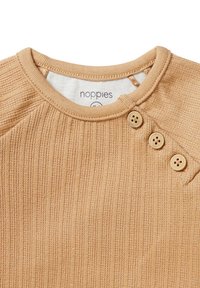 Beige gerippte Bluse mit rundem Halsausschnitt. Verfügt über drei dekorative Knöpfe an der Schulter. Weicher Stoff mit sichtbarem Markenetikett innen.