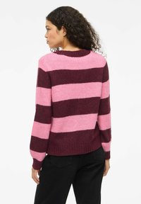 Strickpullover mit breiten horizontalen Streifen in Dunkelrot und Rosa, mit einem gerippten Rundhalsausschnitt und langen Ärmeln. Weiche Textur sichtbar.