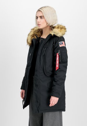 Black parka jacket with a faux fur-lined hood, zipper and button closures, multiple pockets, and an American flag patch on the sleeve.