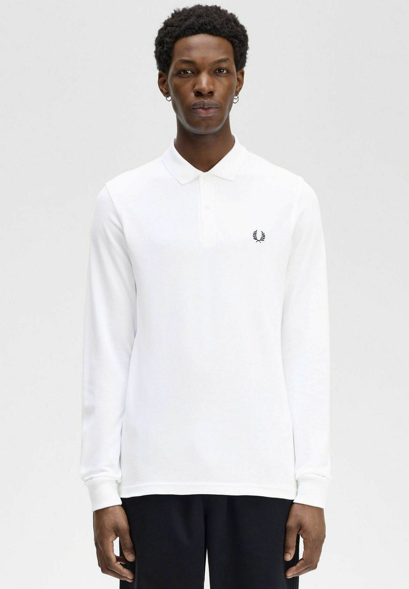 Polo bianco a maniche lunghe con colletto, caratterizzato da un piccolo logo nero ricamato sul lato sinistro del petto; tessuto liscio e design aderente.