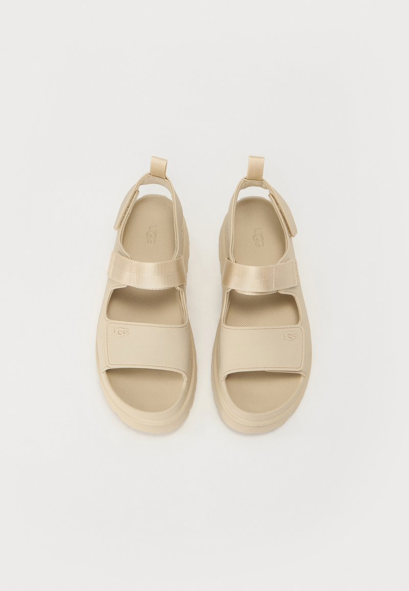 Beige Sandalen mit offenem Zehenbereich, aus glattem synthetischem Material. Mit einem Klettverschluss, strukturiertem Innenfutter und Logodetail.