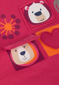 Helles pinkes Gewebe mit Bären- und Herzmotiven, weichen Flanelltexturen und gestickten Akzenten auf mehreren bunten Patches.