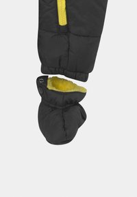 Svarta vadderade vantar med rundad form, försedd med gul fleecefoder. Elastisk mudd ger en tight passform, och tryckknappens detalj förbättrar designen.