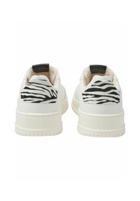 Baskets blanches avec des accents en imprimé zèbre noir sur le talon. Tige texturée, semelle plate et onglet de talon noir. Design minimaliste.