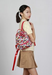 Mochila roja de Hello Kitty con un colorido patrón de dibujos animados, material de tela, correas dobles y un bolsillo frontal con cremallera adornado con un lazo.