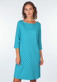 Türkises Kleid mit geometrischem Muster, Dreiviertelärmeln, einem Bootsausschnitt und einer lässigen A-Linien-Form. Hergestellt aus einem weichen, leichten Stoff.