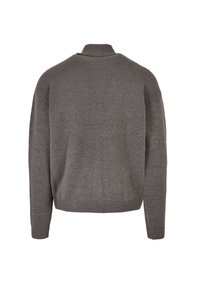 Suéter gris de punto con un cuello alto, hombros caídos y dobladillo acanalado. Textura suave, corte relajado y diseño minimalista.