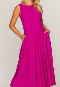 Robe sans manches magenta avec un corsage ajusté, une jupe évasée et des poches. Le matériau semble lisse et légèrement texturé.