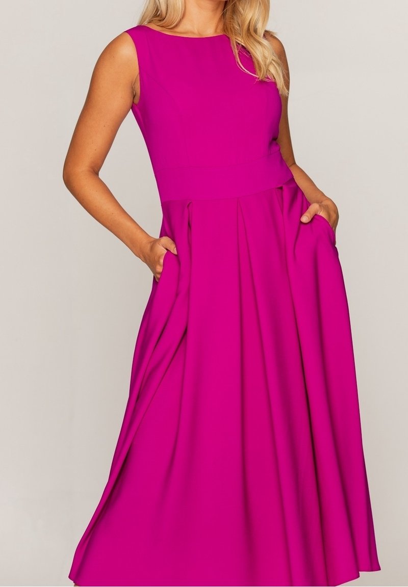 Robe sans manches magenta avec un corsage ajusté, une jupe évasée et des poches. Le matériau semble lisse et légèrement texturé.