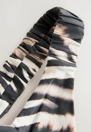 Cinghia in tessuto arricciato di colore nero, bianco e beige con un motivo a righe. Texture liscia con larghezze variabili e raccolte strette lungo la lunghezza.