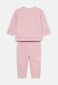 Set di felpa e pantaloni della tuta rosa realizzato in tessuto morbido. Presenta maniche lunghe, caviglie con polsini e dettaglio del logo bianco sui pantaloni.