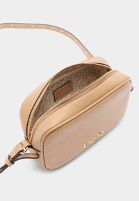 Bež nahkristus kott tekstuuriga viimistlusega, lukuga sulgemine ja mustriline sisemus. Kullaga aktsent, reguleeritav rihm.