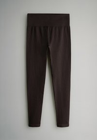 Bruine ribgebreide leggings met een elastische tailleband, taps toelopend ontwerp en een gladde textuur. Geen zichtbare patronen of metalen details.