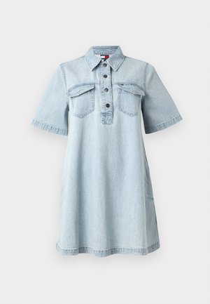 Robe en denim bleu clair avec des manches courtes, un devant à boutons, deux poches sur la poitrine et un col. Coupe droite avec une légère évasement à l'ourlet.