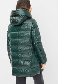 Polstret grøn pufferjakke med en blank finish, hætte og vandret syninger. Designet har en afslappet pasform og sidelommer.