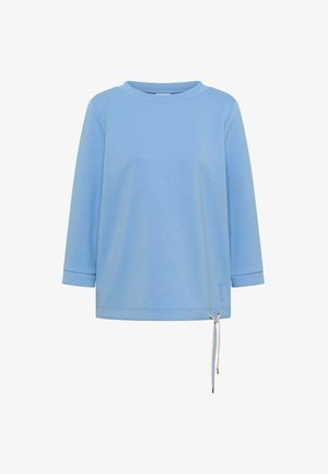 Camisa azul claro de manga larga con cuello redondo y cordón ajustable en el dobladillo, sobre un fondo blanco liso.