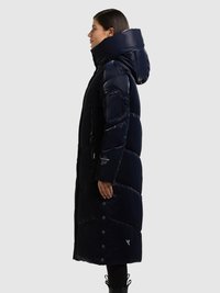 Marineblå pufferjakke med høj krave og aftagelig hætte, der har quiltede sektioner, lynlåslommer i siden og trykknapper langs kanten.