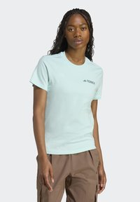 Vaaleansininen puuvillapaita lyhyillä hihoilla. Rinnassa pieni musta "TERREX"-logo. Sujuva rakenne, pyöreä pääntie.