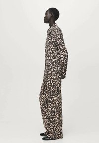 Dolga srajčna obleka v rjavi barvi s svetlo roza abstraktnimi madeži. Ima ovratni izrez in široke, dolge rokave.