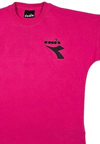 T-shirt fucsia in cotone; presenta un logo nero diagonale sul davanti. Design con colletto girocollo, maniche corte, texture liscia.