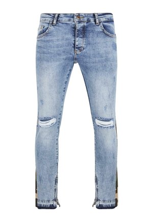 Svijetloplave traperice s izrezima, koje imaju poderotine na koljenima i patentni zatvarač uz vanjske šavove. Slim-fit dizajn.