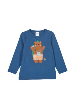 Pitkähihaine sininen paita, jossa on ruskean karhun grafiikka ruudullisessa asussa, reppu ja kiikarit, ommeltuja yksityiskohtia.
